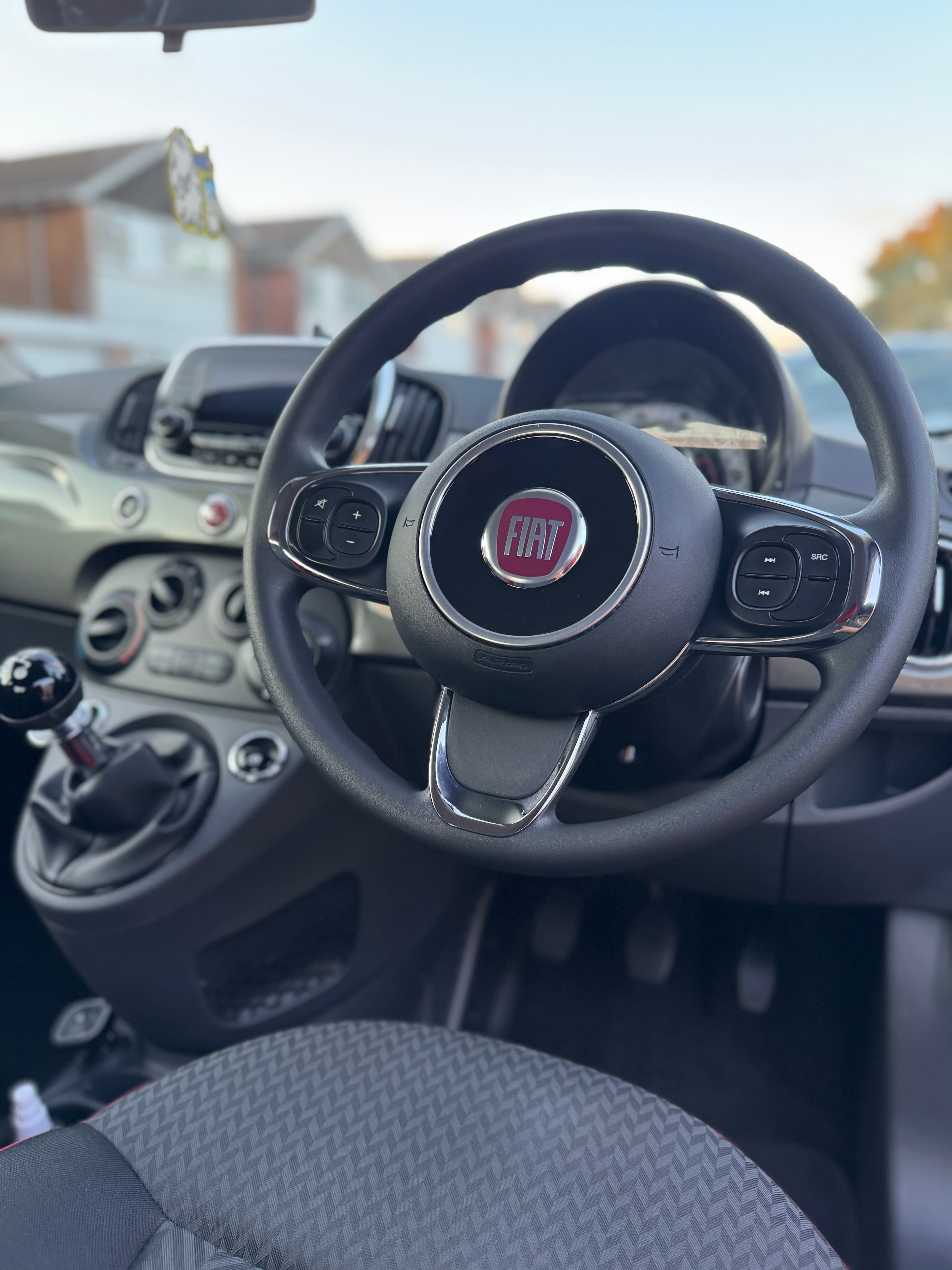 Finished interior — steering wheel and dashboard of a Fiat after detailing
